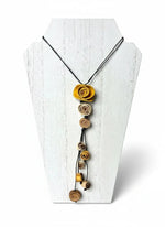 A dainty eco friendly necklace made with rolled orange peel flowers in warm yellow and earthy brown on black cord