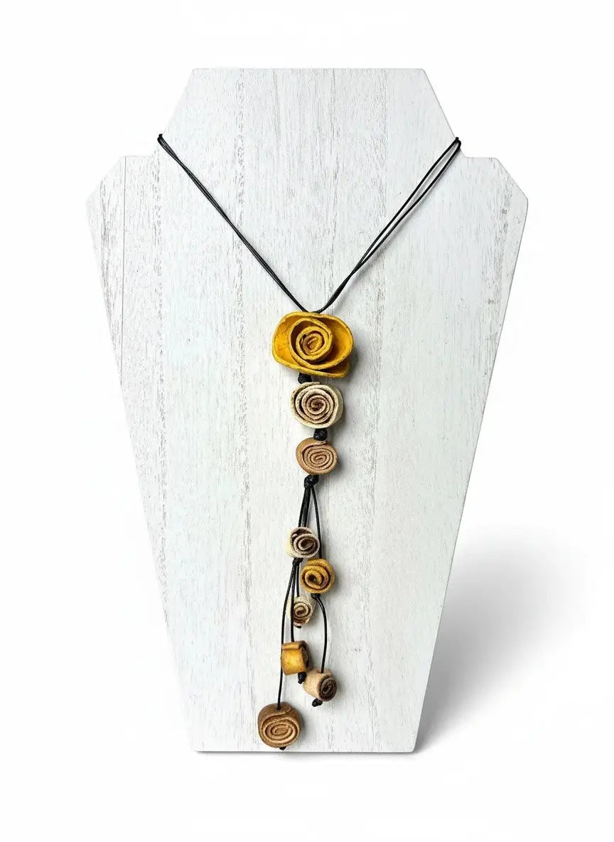 A dainty eco friendly necklace made with rolled orange peel flowers in warm yellow and earthy brown on black cord