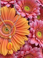 A delicate silver chain orange tagua necklace with yellow bee charm fair trade eco-friendly jewelry gift