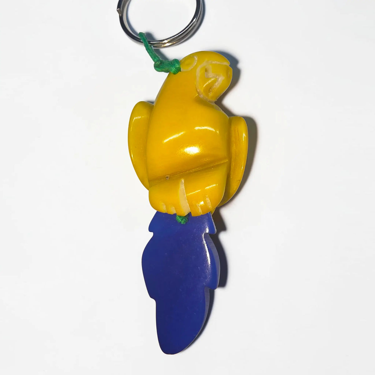 Yellow parrot hand-carved tagua animal keychain with blue tail and green string from rainforest friends critters collection