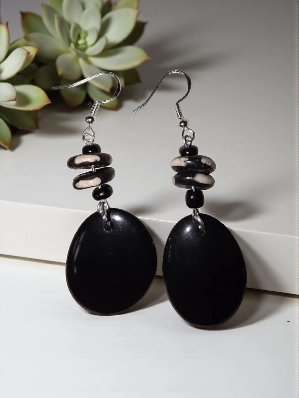 Black oval tagua earrings with matte finish and stacked black and white marbled beads perfect rainforest gifts