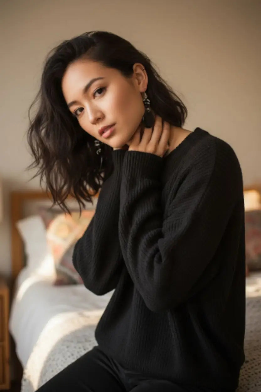 Black ribbed knit sweater shown from the back paired with perfect black polished tagua go-to earrings that protect the rainforest