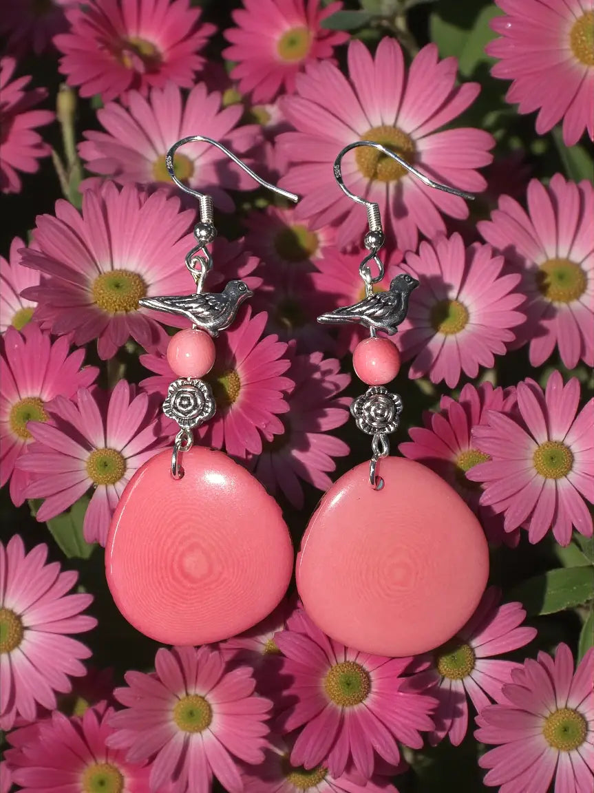 Pink tagua nut slice earrings with teardrop shape silver bird and bead flower accents