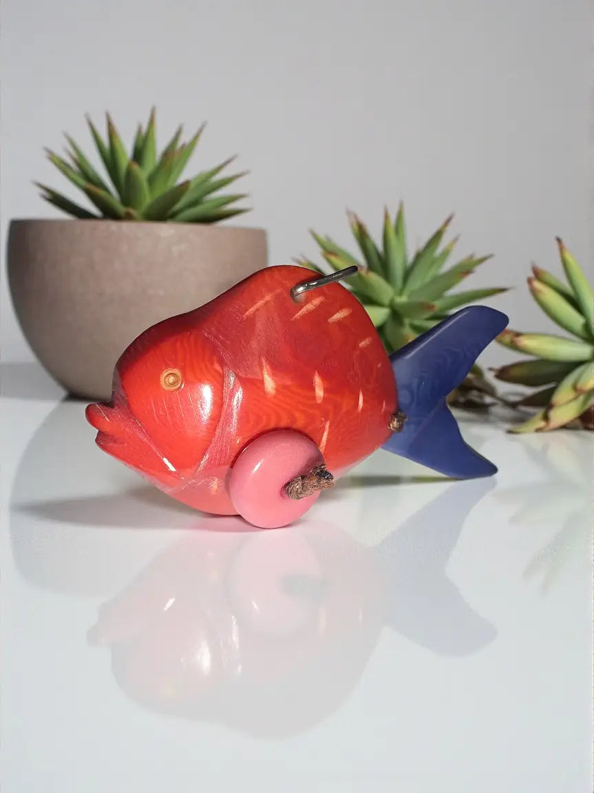 Piranha fish hand-carved tagua animal keychain with vibrant red and blue wood, pink wheels, and detailed carvings