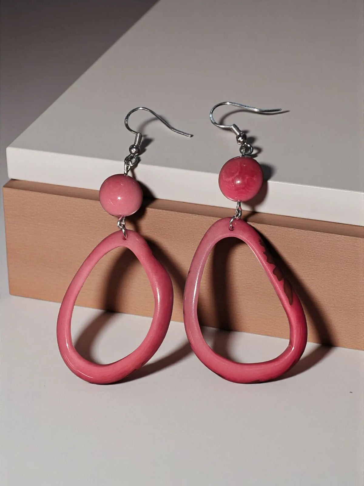 Pink teardrop handmade tagua hoop earrings with a glossy finish and silver hooks for stylish everyday wear