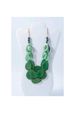 Remy vibrant tagua necklace with green layered oval and teardrop beads accented by dark green spheres and copper hooks