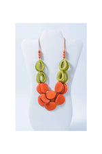 Remy vibrant tagua necklace with loop accents featuring layered orange and lime green circular flat disc beads