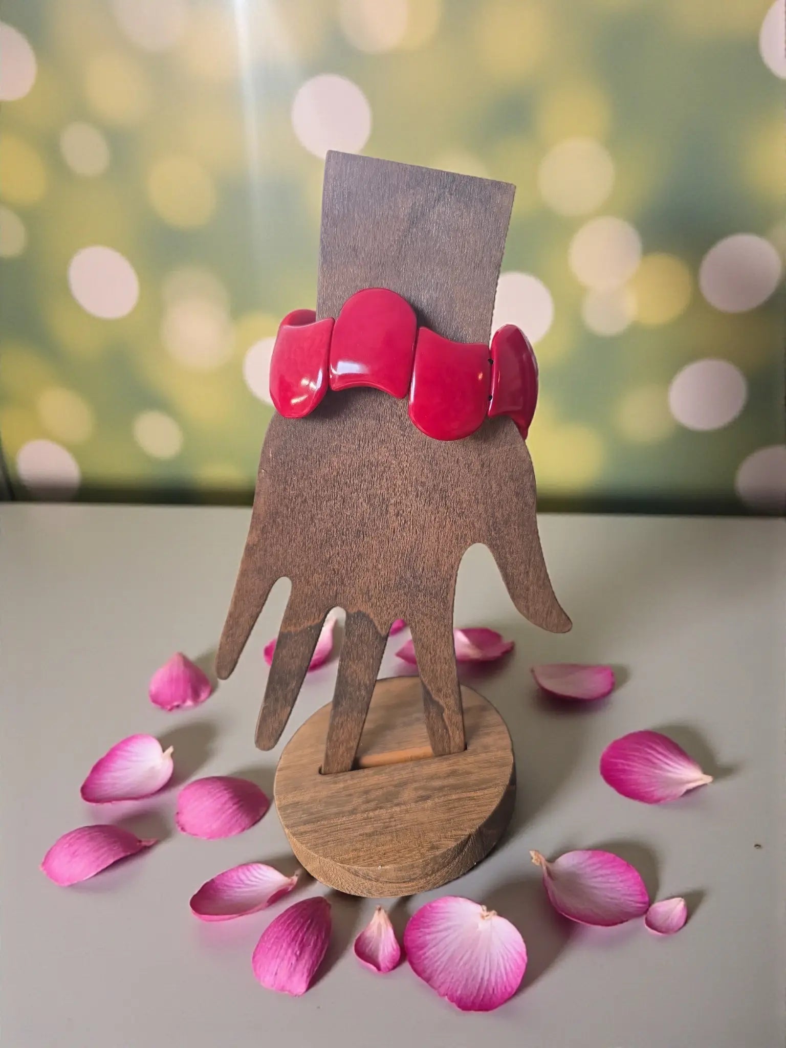 Vibrant red glossy carved tagua nut forest seed bracelet with chunky design displayed on wooden hand stand