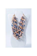 A layered scarf tagua necklace with chunky pastel pink and navy curved links made from natural eco tagua material