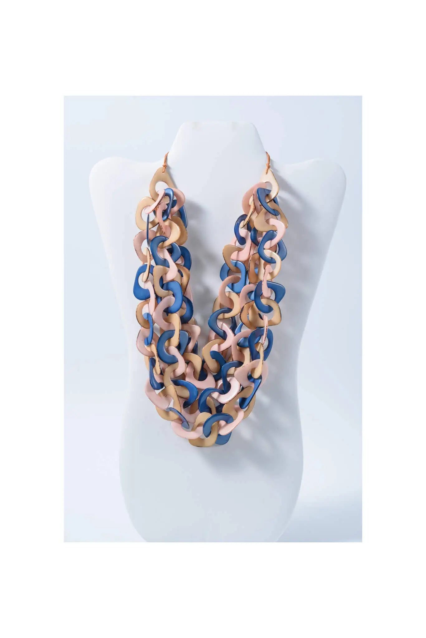A layered scarf tagua necklace with chunky pastel pink and navy curved links made from natural eco tagua material