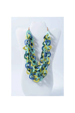 A vibrant three-stranded scarf tagua necklace with interlocking teal, blue, and yellow links made from natural tagua