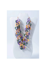 A vibrant three-stranded scarf tagua necklace with purple green and yellow interlocking links made from natural tagua