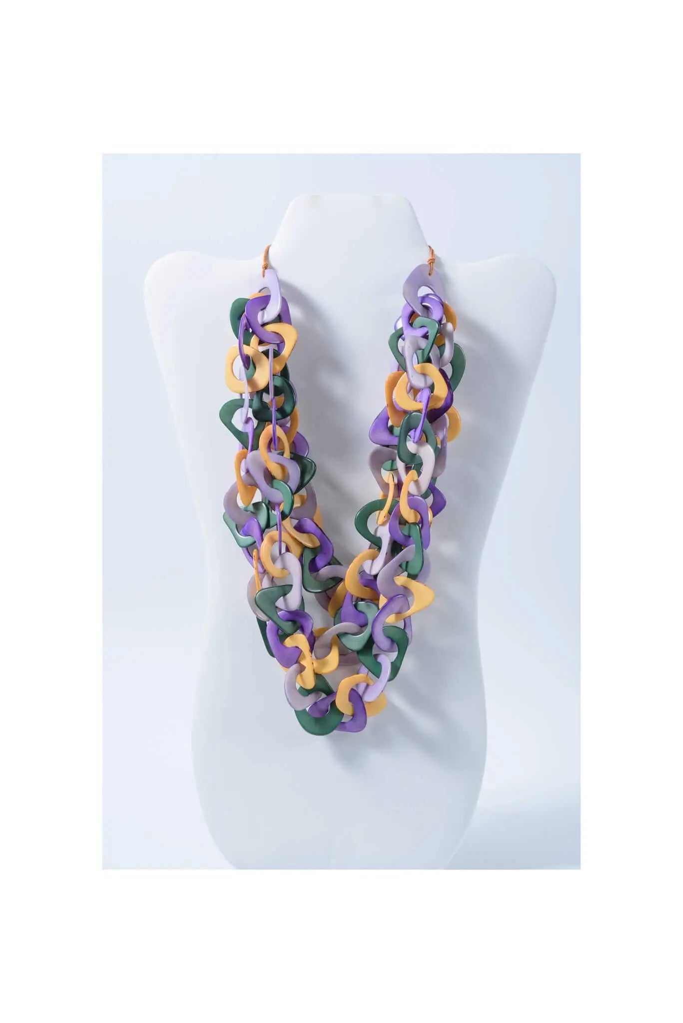 A vibrant three-stranded scarf tagua necklace with purple green and yellow interlocking links made from natural tagua