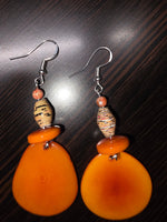 Stunning dreamy orangesickle tagua slice earrings feature orange teardrop beads wrapped in paper with silver hook clasps
