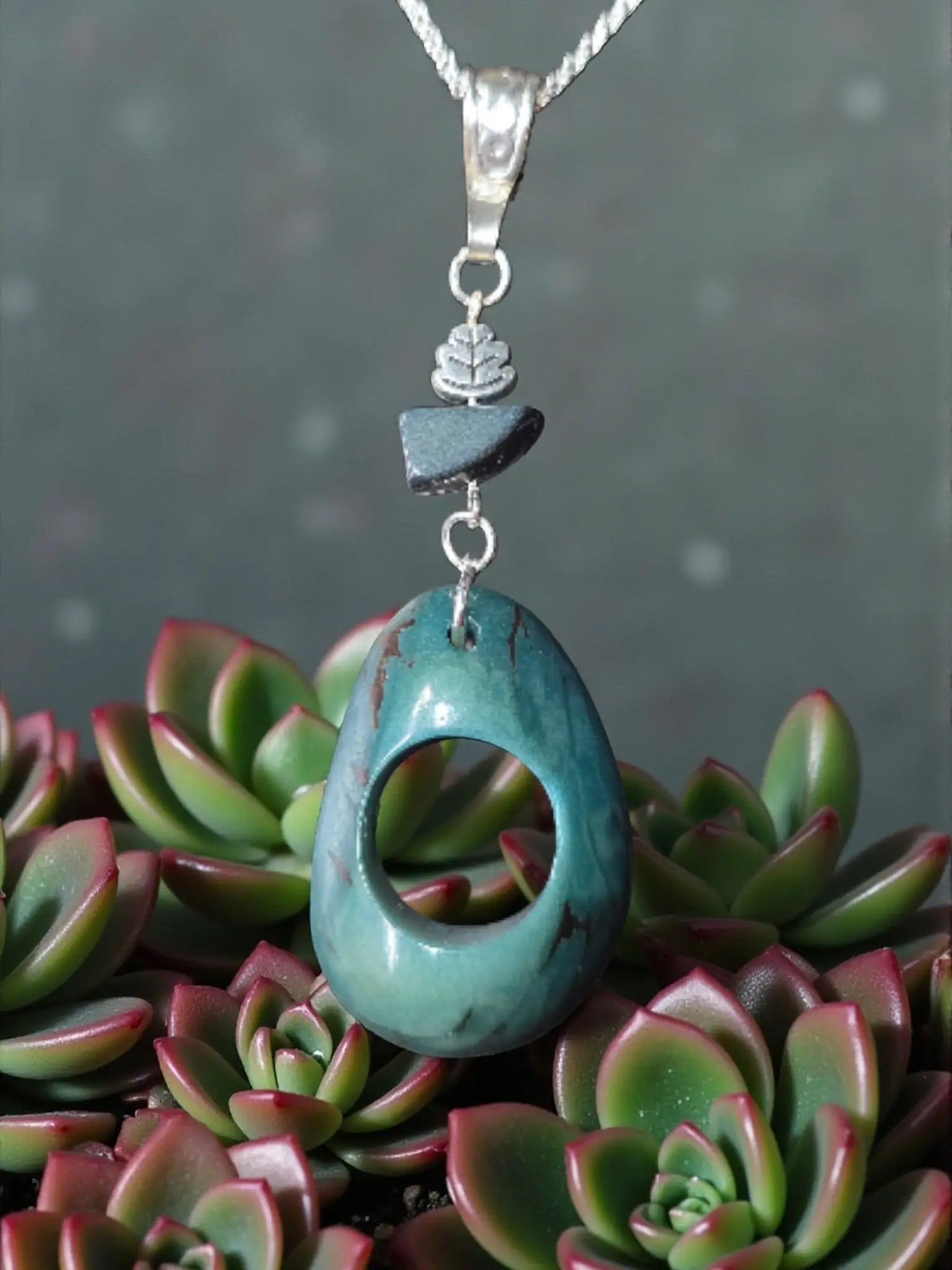 Stunning fair trade thick carved turquoise polished tagua nut necklace with central hole and silver leaf charm pendant