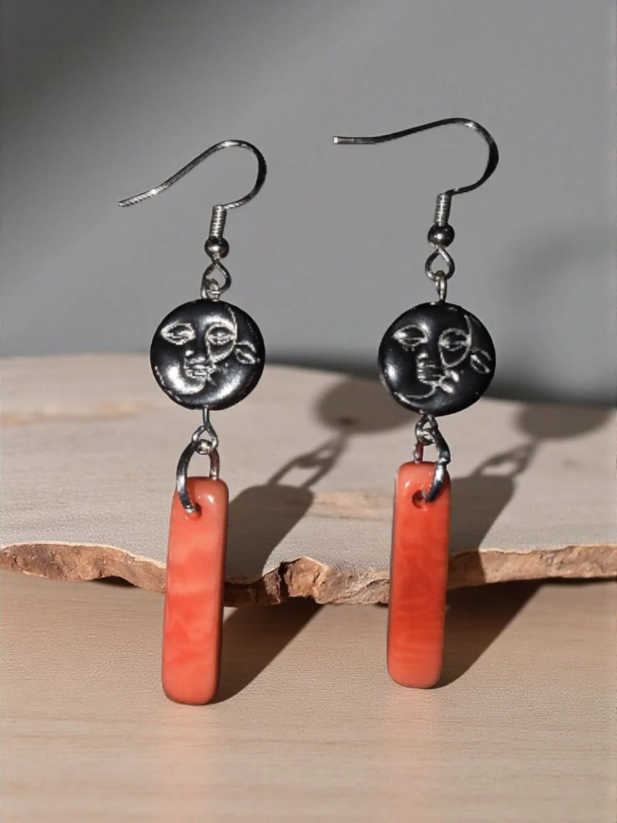 Silver-toned dangle earrings with circular moon face charm and orange peach melon tagua stone pendant