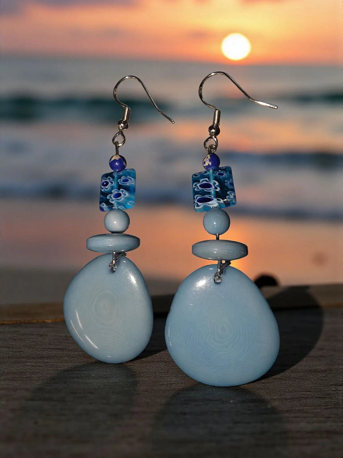 Light blue sky blue tagua slice earrings feature teardrop glass with glossy finish and floral bead accents