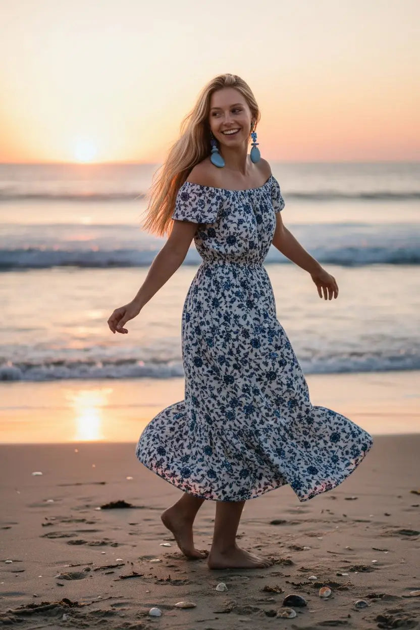 A woman wears sky blue tagua slice earrings with glass flower beads paired with a white navy blue floral midi dress