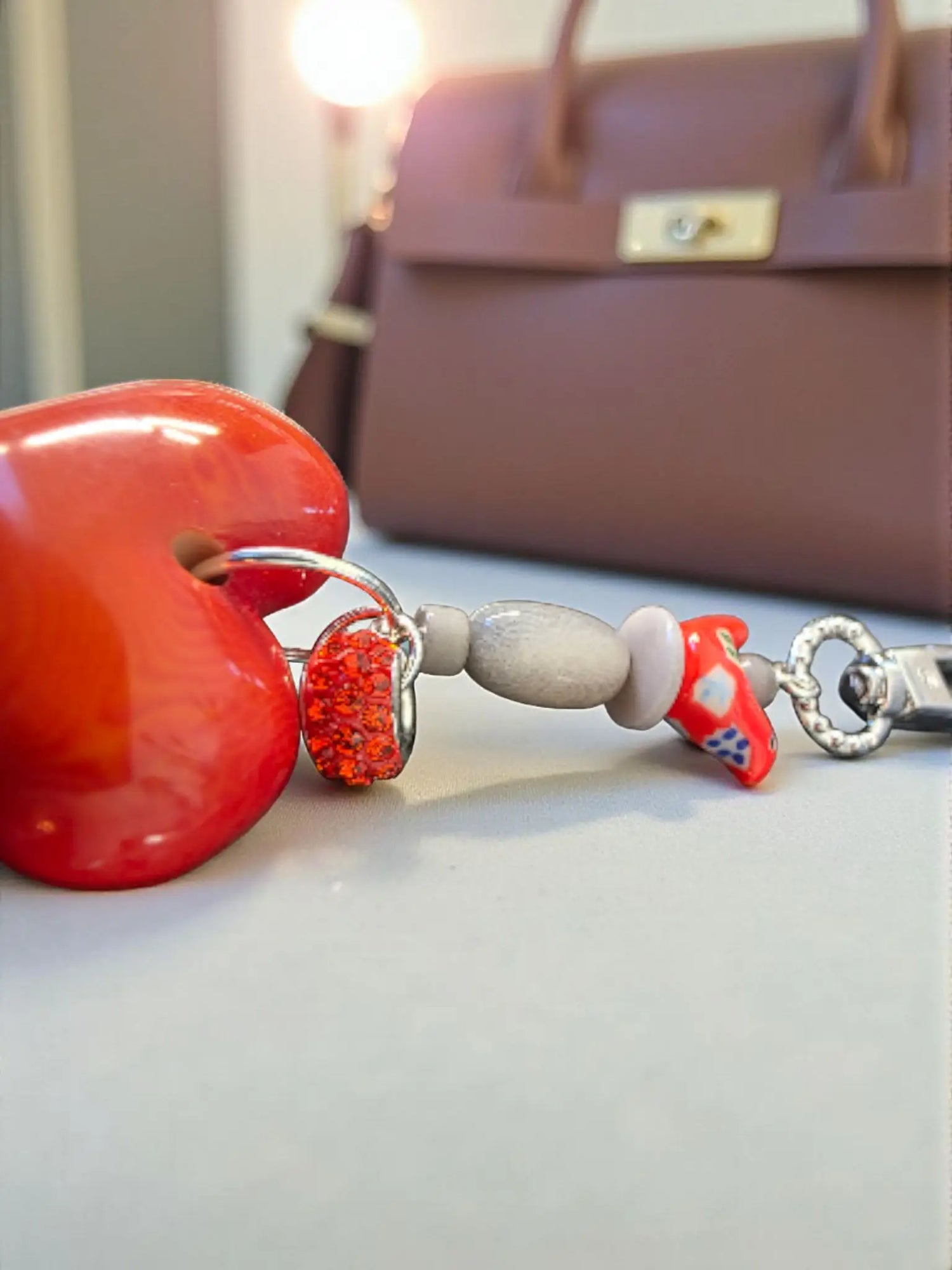 Vibrant red glossy heart-shaped carved tagua keychain with silver chain and ceramic folk art bird bead charm