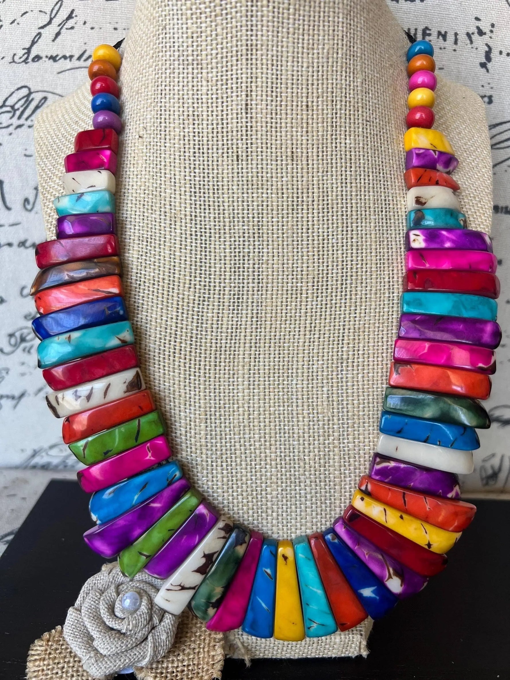 Vibrant multicolored tagua nut necklace with a textured burlap rose pendant handmade and adjustable