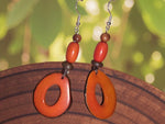Thick natural donut tagua hoop handmade earrings in orange crush with a glossy finish and earthy bead accents