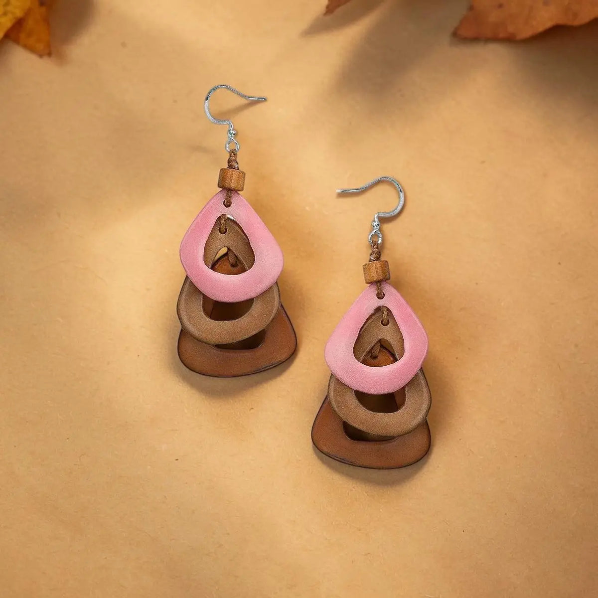 Pink and brown layered teardrop katniss earrings feature carved tagua nut and wooden accents for a natural look