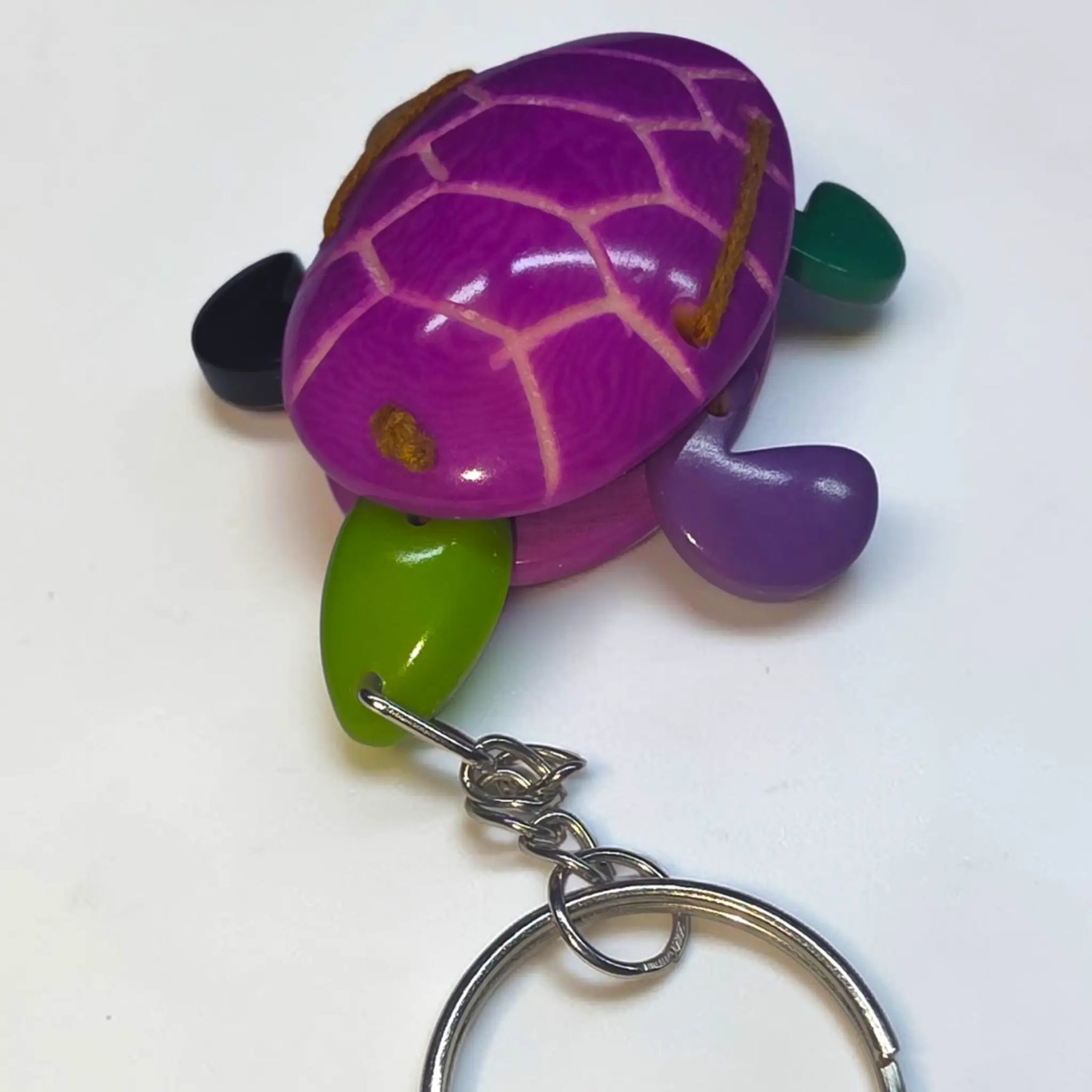 Purple wooden turtle keychain with green and black accents from hand-carved tagua animal keychains collection