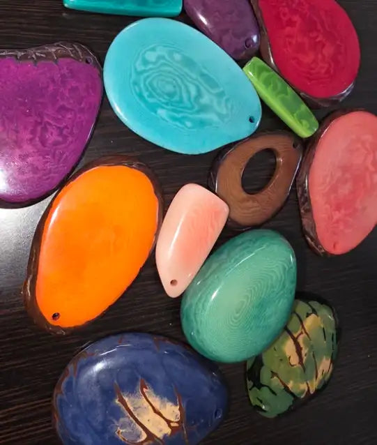 Vibrant, glossy resin beads in assorted organic shapes and swirling color patterns.