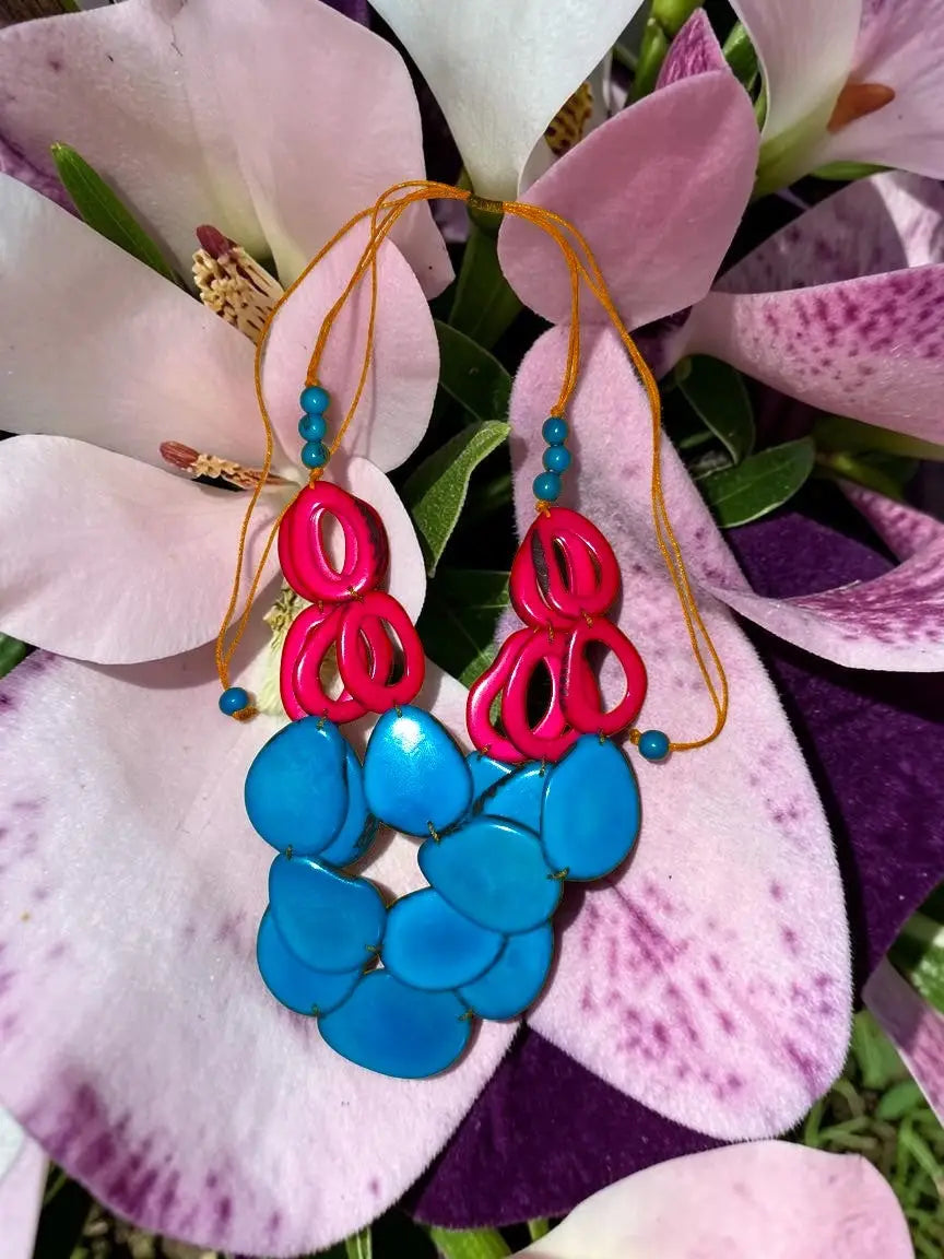 Vibrant pink and turquoise tagua nut statement necklace with bold sculptural design and loop accents by remy