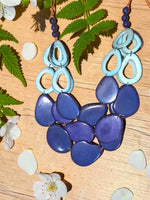 Vibrant vibrant slices of polished tagua nut statement necklace in blue with layered tagua beads and loop accents
