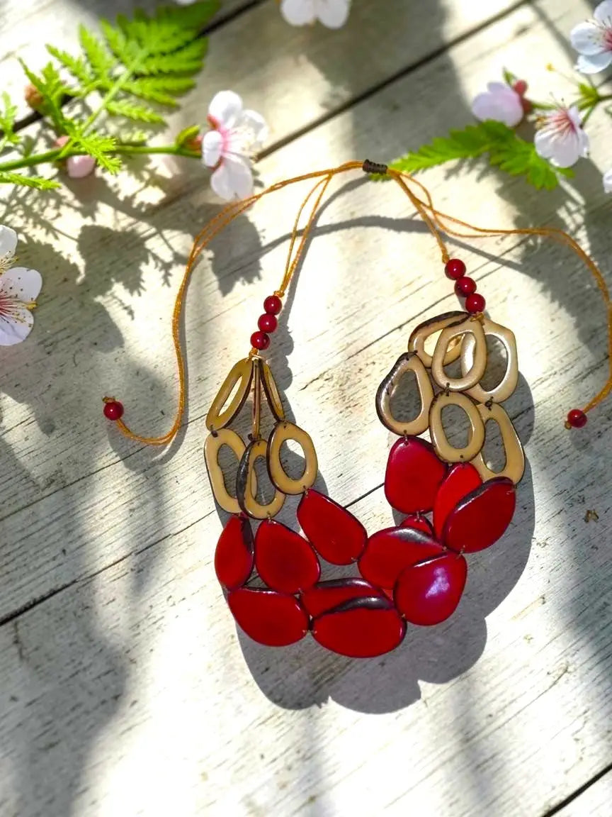 Vibrant slices of polished tagua nut statement necklace in red and gold with glossy tagua beads and loop accents